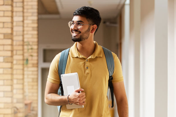 Student holding tablet smiling