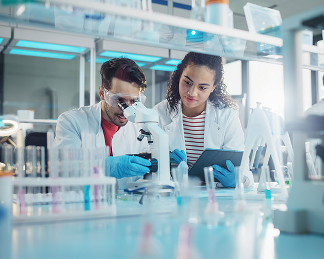 Two scientists in lab coats work together in a modern lab